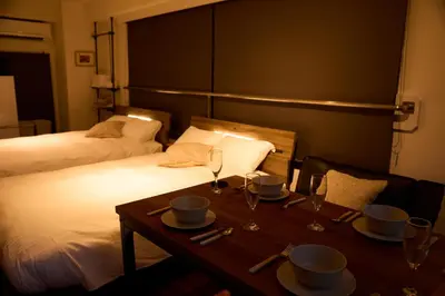 a room with a table and a bed with two beds at Kaminari INN in Tokyo