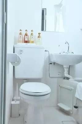 a white bathroom with a toilet and a sink at Kaminari INN in Tokyo