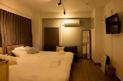 a hotel room with two beds and a television at Kaminari INN in Tokyo