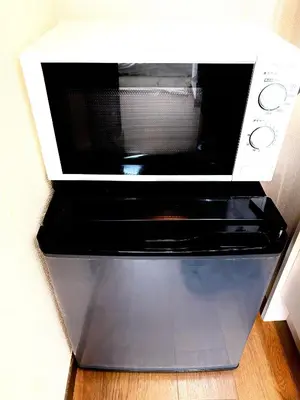 a microwave oven sitting on top of a wooden floor at \u30af\u30aa\u30ea\u30c6\u30a3\u30cf\u30a4\u30c4101\u53f7\u5ba4 in Tokyo