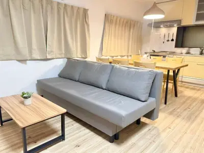 a living room with a couch and a table at \u967d\u6668\u30af\u30ea\u30b9\u30bf\u30eb\u4e09\u30ce\u8f2a\u65c5\u9928 in Tokyo