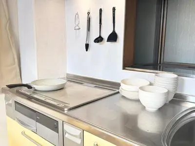 a kitchen with white bowls and utensils on a counter at \u967d\u6668\u30af\u30ea\u30b9\u30bf\u30eb\u4e09\u30ce\u8f2a\u65c5\u9928 in Tokyo