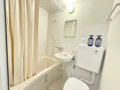 a white bathroom with a toilet and a sink at \u967d\u6668\u30af\u30ea\u30b9\u30bf\u30eb\u4e09\u30ce\u8f2a\u65c5\u9928 in Tokyo