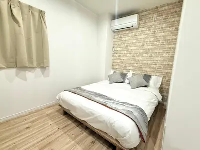a bed in a room with a brick wall at \u967d\u6668\u30af\u30ea\u30b9\u30bf\u30eb\u4e09\u30ce\u8f2a\u65c5\u9928 in Tokyo