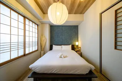 a bedroom with a white bed with a large window at Chill Place 133 Keisei Koiwa in Tokyo