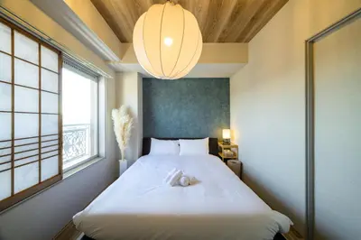 a bedroom with a large white bed with a light fixture at Chill Place 133 Keisei Koiwa in Tokyo