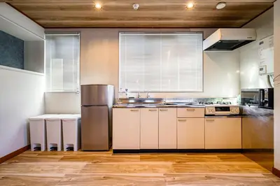 a kitchen with white cabinets and a stainless steel refrigerator at Chill Place 133 Keisei Koiwa in Tokyo