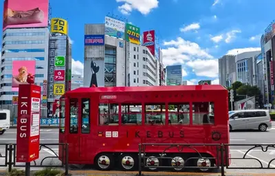 a red bus on a city street with buildings at 5-min walk from Higashi-Ikebukuro your second home in Tokyo