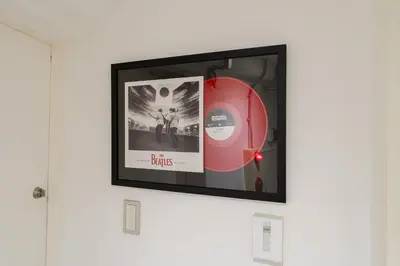 a picture of a red cd on a wall at Shibuya Beatles house 10min walk from Shibuya Station in Tokyo