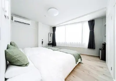a white bedroom with a large bed and a window at Alice JueQie 1minute walk to Horikiri Station ,Super convenient transportation ,Direct access to Narita Airport , Drugstore, convenience store, and shopping center downstairs in Tokyo