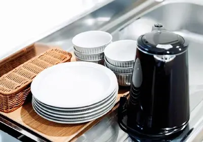 a stack of white plates and a coffee maker at Alice JueQie 1minute walk to Horikiri Station ,Super convenient transportation ,Direct access to Narita Airport , Drugstore, convenience store, and shopping center downstairs in Tokyo