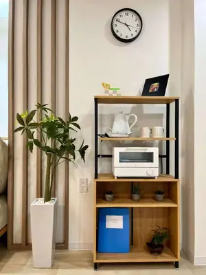 a shelf with a microwave and a clock on a wall at Designer 2BR with Japanese & Western Style Near Shinjuku Subway 5-Min up to 6 people in Tokyo