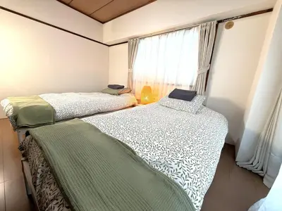 two beds in a room with a window at LT Oshiage in Tokyo
