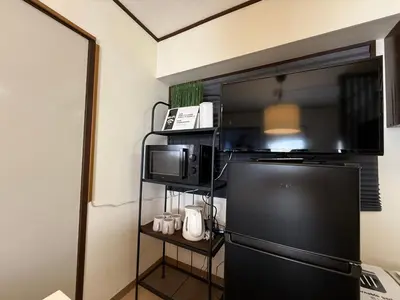 a kitchen with a refrigerator and a microwave at LT Oshiage in Tokyo