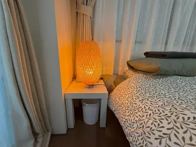 a lamp sitting on a table next to a bed at LT Oshiage in Tokyo