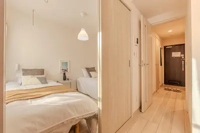 a bedroom with two beds and a hallway at Mi-Hotel Ikebukuro in Tokyo