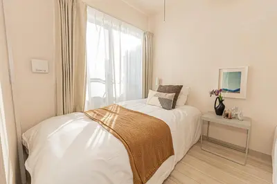 a white bedroom with a bed and a window at Mi-Hotel Ikebukuro in Tokyo