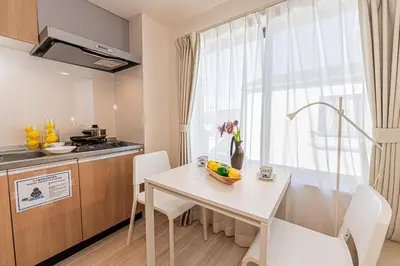 a small kitchen with a white table and chairs at Mi-Hotel Ikebukuro in Tokyo