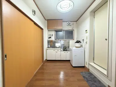 a small kitchen with white cabinets and a white refrigerator at Nogata RelaxingHome E2 in Tokyo