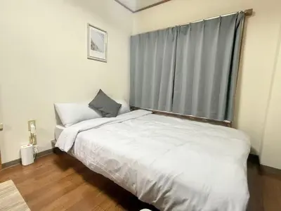 a bedroom with a large bed and a window at Nogata RelaxingHome E2 in Tokyo