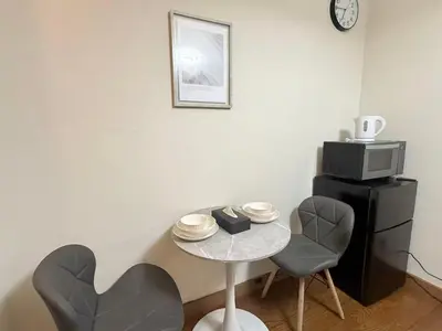 a small table with two chairs and a microwave at Nogata RelaxingHome E2 in Tokyo
