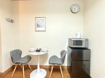 a kitchen with a table and two chairs and a microwave at Nogata RelaxingHome E2 in Tokyo