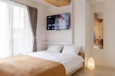 a bedroom with a bed with a tv on the wall at House Hotel Shin Ekoda401 DE41 in Tokyo