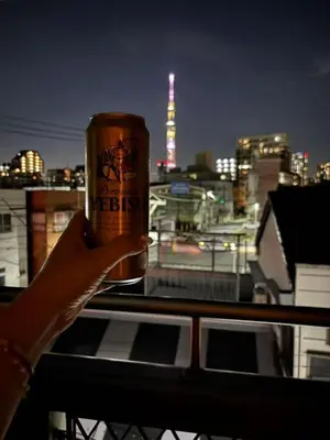 a person holding a coffee cup on a balcony at Quiet and beautiful house nearby Tokyo Skytree in Tokyo