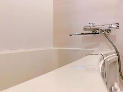 a bathtub with a hose hooked up to a sink at Harajuku house in Tokyo