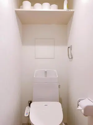 a white bathroom with a toilet and a shelf at Harajuku house in Tokyo