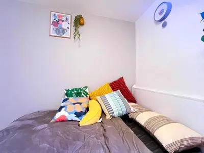a bedroom with a bed with colorful pillows at Harajuku house in Tokyo