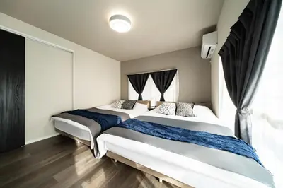 a bedroom with two beds and a window at 109, Nishiarai, \u897f\u65b0\u4e95 \u65b0\u898f\u30aa\u30fc\u30d7\u30f3, \u6771\u4eac\u89b3\u5149\u306b\u6700\u9069, 10\u540d\u69d8\u3054\u5229\u7528\u53ef\u80fd in Tokyo