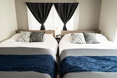 two beds in a room with a window at 109, Nishiarai, \u897f\u65b0\u4e95 \u65b0\u898f\u30aa\u30fc\u30d7\u30f3, \u6771\u4eac\u89b3\u5149\u306b\u6700\u9069, 10\u540d\u69d8\u3054\u5229\u7528\u53ef\u80fd in Tokyo
