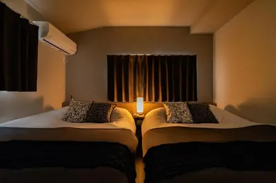 two beds sitting in a room with a window at 109, Nishiarai, \u897f\u65b0\u4e95 \u65b0\u898f\u30aa\u30fc\u30d7\u30f3, \u6771\u4eac\u89b3\u5149\u306b\u6700\u9069, 10\u540d\u69d8\u3054\u5229\u7528\u53ef\u80fd in Tokyo