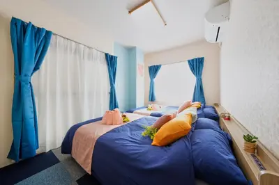 two beds in a room with blue curtains at Shamrock Aoto 304 Cozy Tokyo Stay Near Station Airport Disney Access in Tokyo