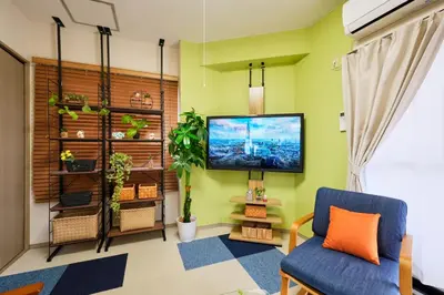 a living room with a tv on a green wall at Shamrock Aoto 304 Cozy Tokyo Stay Near Station Airport Disney Access in Tokyo