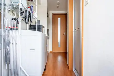 a hallway with a white refrigerator in a room at Opening January 2026 Just a five minute walk from Tabata Station on the Yamanote Line with direct access to Ikebukuro Shinjuku Shibuya and Ueno Comfortably sleeps 3 accommodates up to five guests in Tokyo