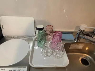 a group of glass bottles sitting on a counter next to a sink at \u3055\u304f\u3089\u65c5\u9928 \u9ad8\u5186\u5bfa\u5317\u5343\u5229\u4f11 b101\u53f7\u5ba4 in Tokyo