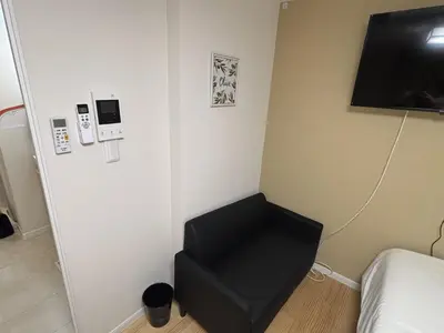 a room with a black chair and a television at \u3055\u304f\u3089\u65c5\u9928 \u9ad8\u5186\u5bfa\u5317\u5343\u5229\u4f11 b101\u53f7\u5ba4 in Tokyo