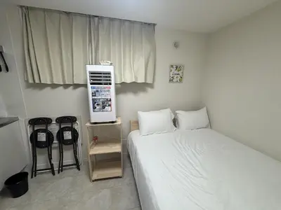 a small room with a bed and a air conditioner at \u3055\u304f\u3089\u65c5\u9928 \u9ad8\u5186\u5bfa\u5317\u5343\u5229\u4f11 \uff42102\u53f7\u5ba4 in Tokyo
