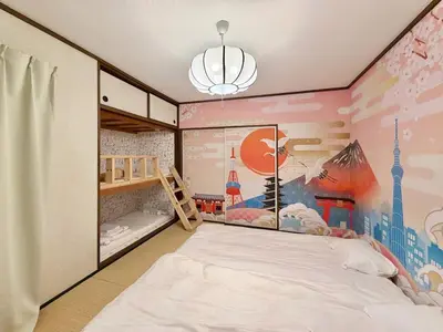a bedroom with a bed and a wall with a mural at \u30a8\u30de\u30fc\u30ec\u6771\u5c0f\u5ca9201 \u5c0f\u5ca9\u99c5\u5f92\u6b695\u5206 \u6700\u59279\u540d \u548c\u5ba4\u7573 in Tokyo