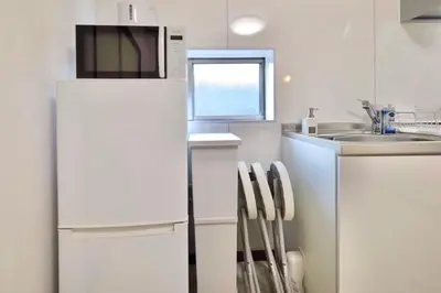 a white kitchen with a refrigerator and a sink at \u30a8\u30de\u30fc\u30ec\u6771\u5c0f\u5ca9201 \u5c0f\u5ca9\u99c5\u5f92\u6b695\u5206 \u6700\u59279\u540d \u548c\u5ba4\u7573 in Tokyo
