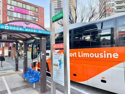 an orange and white bus parked at a bus stop at \u30a8\u30de\u30fc\u30ec\u6771\u5c0f\u5ca9201 \u5c0f\u5ca9\u99c5\u5f92\u6b695\u5206 \u6700\u59279\u540d \u548c\u5ba4\u7573 in Tokyo