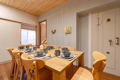 a dining room with a wooden table and chairs at Maison Shin Nakano 101 MS11 in Tokyo