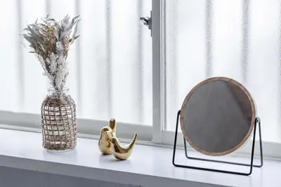 a mirror sitting on a shelf next to a vase with flowers at Maison Shin Nakano 101 MS11 in Tokyo