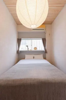 a bedroom with a bed with a chandelier above it at Maison Shin Nakano 101 MS11 in Tokyo