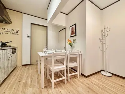a white dining room with a white table and chairs at \u30a8\u30de\u30fc\u30ec\u6771\u5c0f\u5ca9101 \u5c0f\u5ca9\u99c5\u5f92\u6b695\u5206 \u6700\u59277\u540d \u548c\u5ba4\u7573 in Tokyo