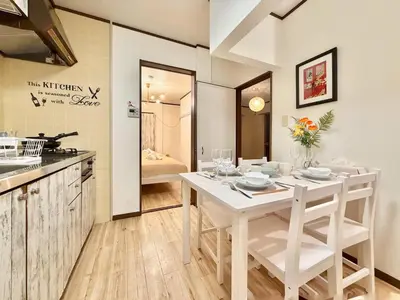 a kitchen and dining room with a white table and chairs at \u30a8\u30de\u30fc\u30ec\u6771\u5c0f\u5ca9101 \u5c0f\u5ca9\u99c5\u5f92\u6b695\u5206 \u6700\u59277\u540d \u548c\u5ba4\u7573 in Tokyo