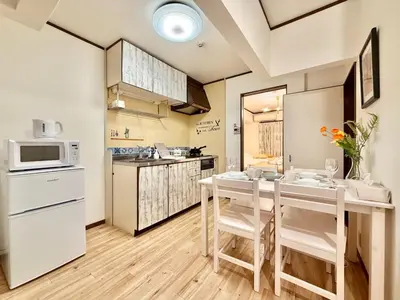 a kitchen with a table and chairs and a microwave at \u30a8\u30de\u30fc\u30ec\u6771\u5c0f\u5ca9101 \u5c0f\u5ca9\u99c5\u5f92\u6b695\u5206 \u6700\u59277\u540d \u548c\u5ba4\u7573 in Tokyo