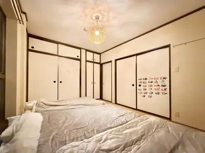 a bedroom with a large bed and a chandelier at \u30a8\u30de\u30fc\u30ec\u6771\u5c0f\u5ca9101 \u5c0f\u5ca9\u99c5\u5f92\u6b695\u5206 \u6700\u59277\u540d \u548c\u5ba4\u7573 in Tokyo